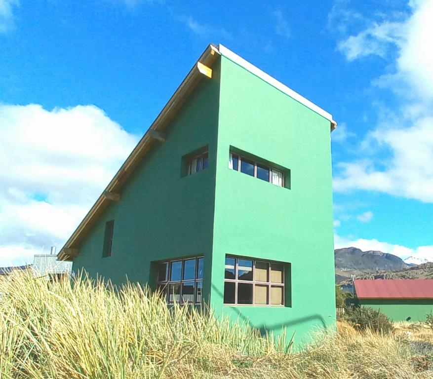 una casa con un techo puntiagudo en la parte superior de un campo en La Ribera - Sepúlveda 191 en El Chaltén