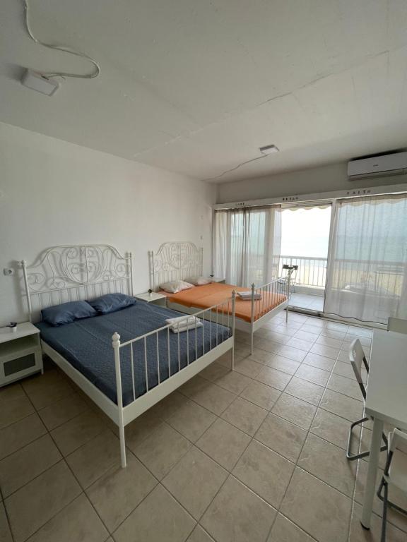 een slaapkamer met een bed en een kamer met een balkon bij Breeze Apartments in Perea