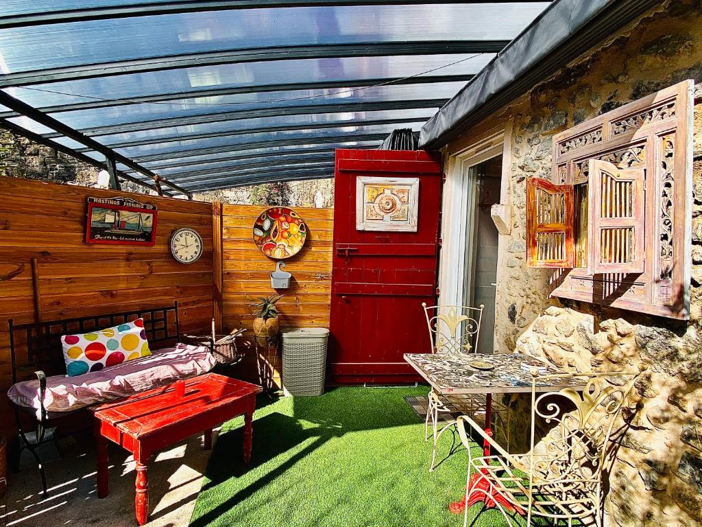 a patio with a table and a red door at Studio le moulin de Pascale in Espelette