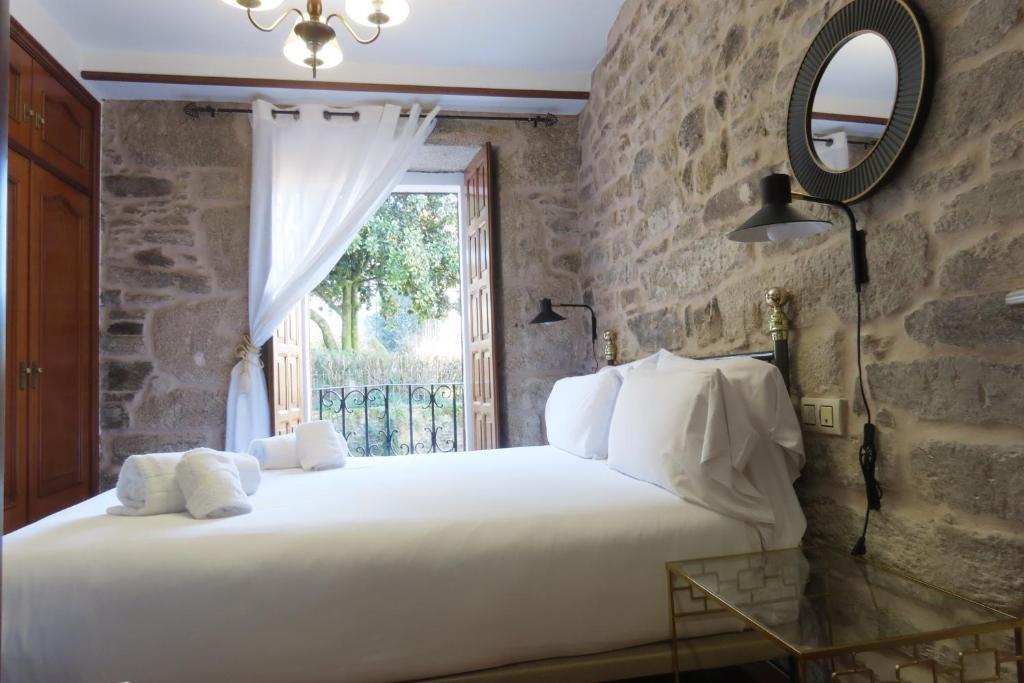 a bedroom with a large white bed and a window at Sete Artes by Como en Casa in Santiago de Compostela