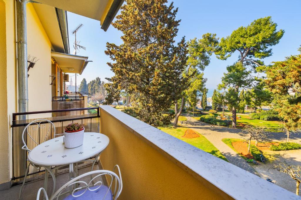 a balcony with a table and chairs and a view of a street at Premium apartment Peschiera Porec in Poreč