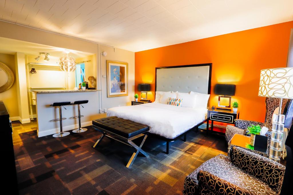 Schlafzimmer mit einem großen weißen Bett und orangefarbenen Wänden in der Unterkunft Hotel Royal Oak in Royal Oak