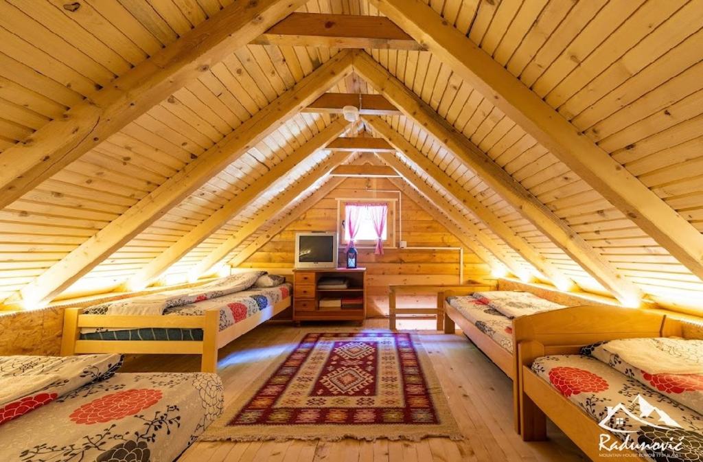 una camera con quattro letti in una casa di legno di Mountain House Komovi ad Andrijevica