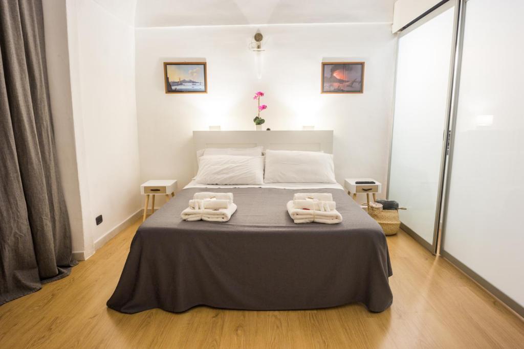 een slaapkamer met een bed met twee handdoeken erop bij Residenza Sforza Apartment 2 in Napels