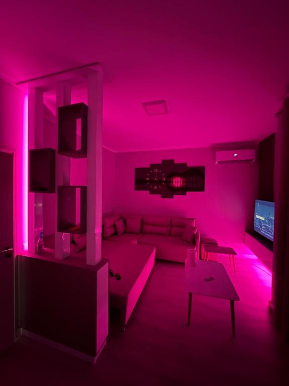 een woonkamer met roze verlichting en een bank bij 090 Area in Tirana