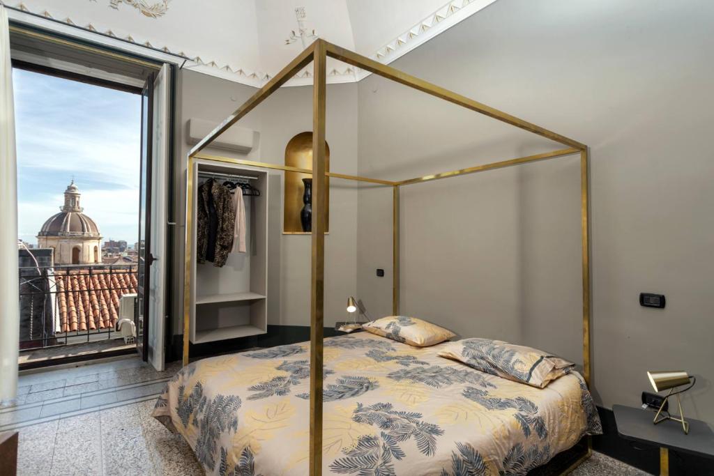 a bedroom with a canopy bed and a balcony at 81 Suite and Breakfast in Catania