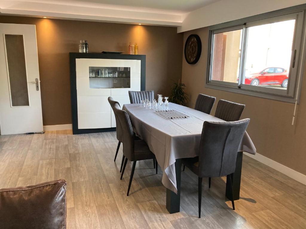 uma sala de jantar com mesa e cadeiras em Nouveau !! Bel appartement à Fécamp tout près de la plage, gare et voie verte em Fécamp