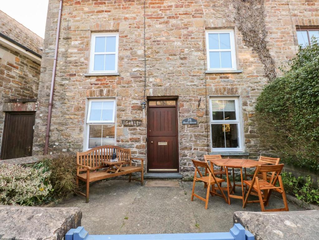 a patio with a table and chairs in front of a brick building at Rock House in Haverfordwest