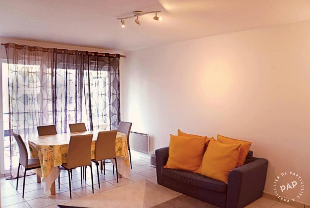 a dining room with a table and a couch at Superbe appartement T2 de 50m2 près de Genève à Saint Julien en Genevois idéal pour couple avec 2 enfants jusqu'à 18 ans in Saint-Julien-en-Genevois