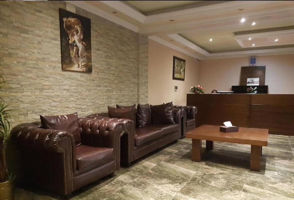 una sala de espera con sofás de cuero y mesa de centro en Hotel Murex en Brazzaville