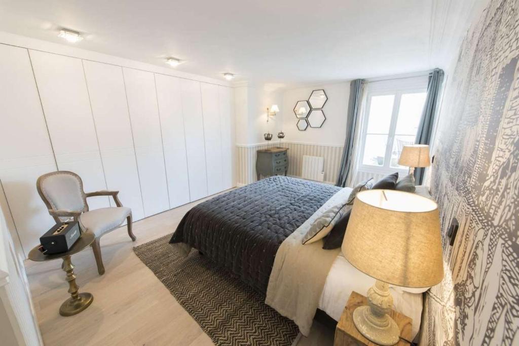 um quarto com uma cama, uma cadeira e um candeeiro em Leocadia em Paris