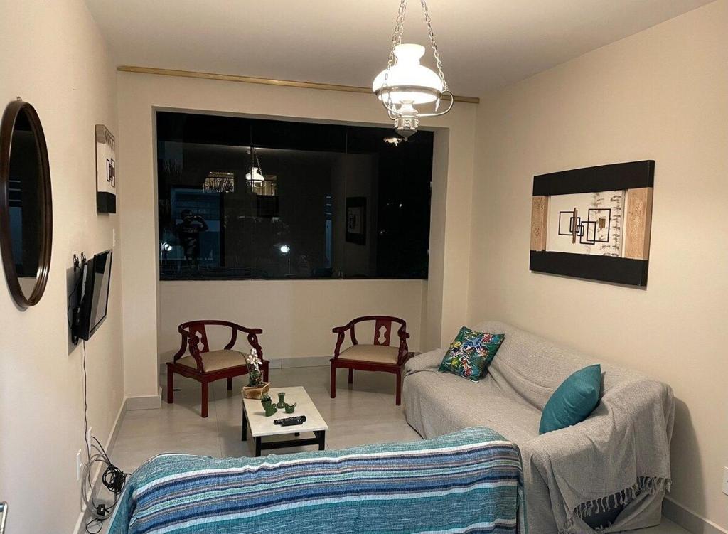 uma sala de estar com um sofá e uma mesa em Apartamento confortável na praça central em Águas de Lindoia