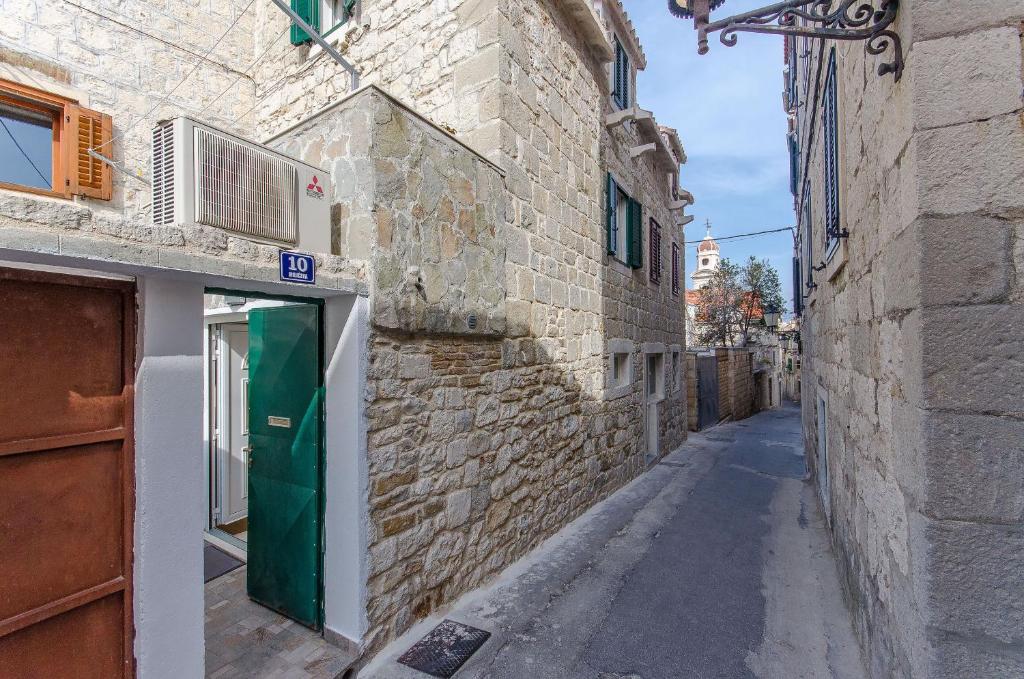 um beco com uma porta verde num edifício de pedra em Apartment Ane em Split