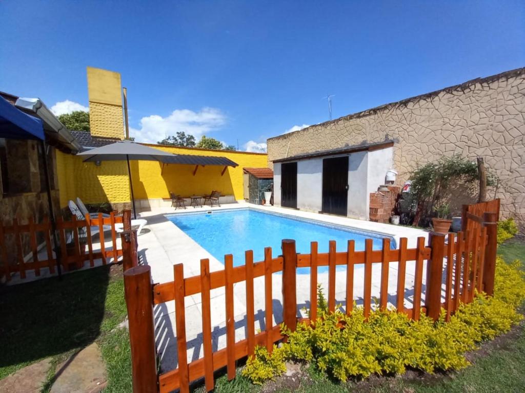 a swimming pool with a wooden fence next to a house at La Fondita in San Salvador de Jujuy