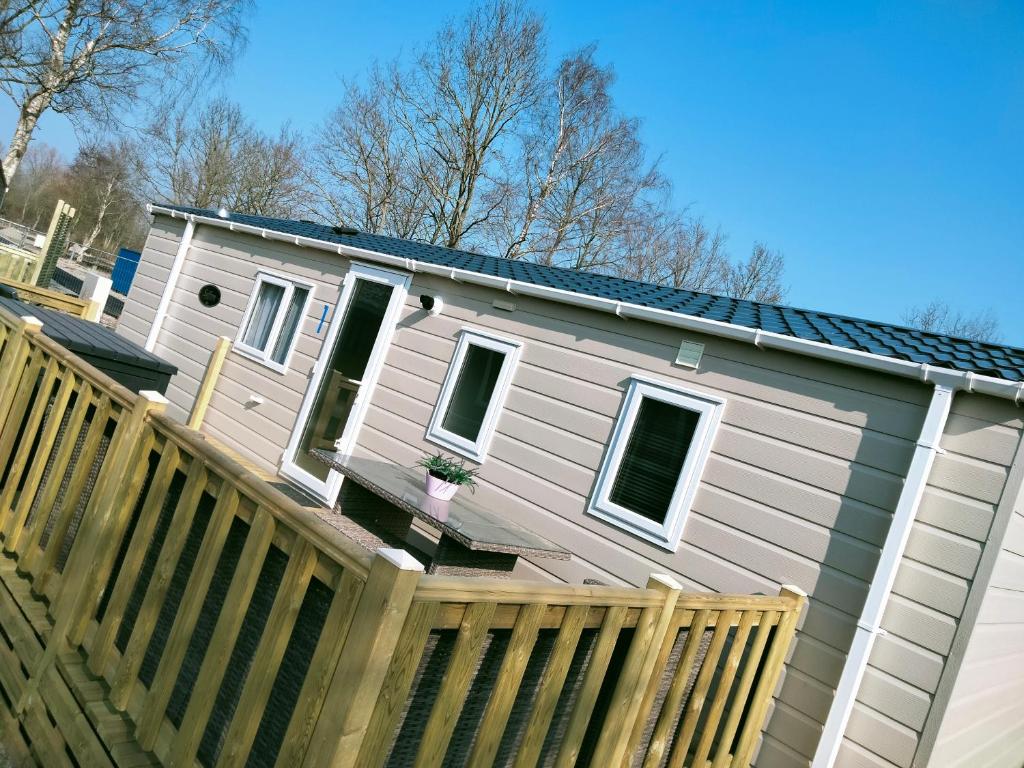 een huis met een houten hek ervoor bij BJ Chalets - De Rug 1 - Vakantiepark Lauwersoog - LUXE, kindvriendelijke chalet MET vaatwasser! Vroege incheck! in Lauwersoog