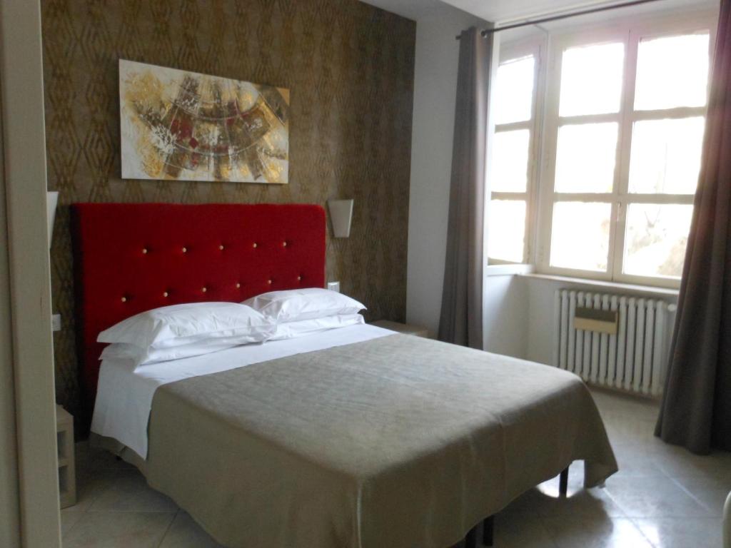 a bedroom with a large bed with a red headboard at B&B Domus Chiara in Rome
