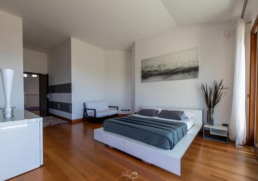 sypialnia z łóżkiem w białym pokoju w obiekcie LANGA SUNSET VILLA w mieście Belvedere Langhe