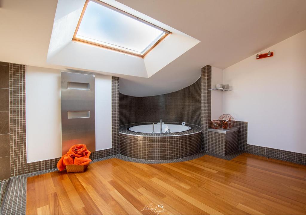 duża łazienka z wanną i świetlikiem w obiekcie LANGA SUNSET VILLA w mieście Belvedere Langhe
