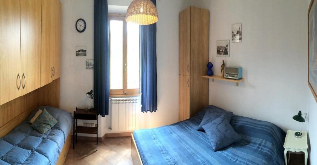 Un dormitorio con una cama azul y una ventana en Casa Martellina - Holiday Home, en Bagno a Ripoli