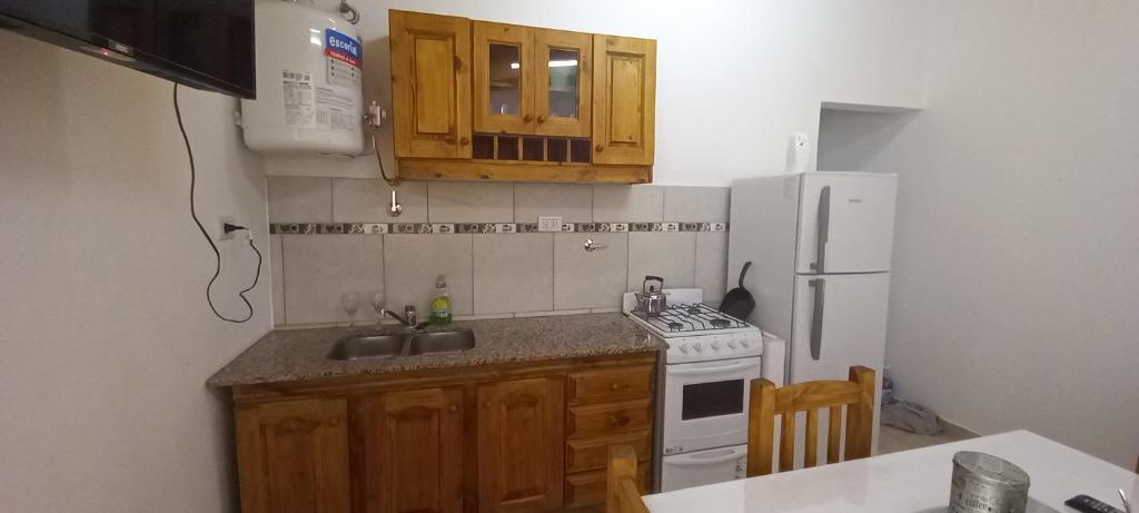 a kitchen with a sink and a stove and a refrigerator at Departamentos x dia Viedma 2 CON COCHERA in Viedma