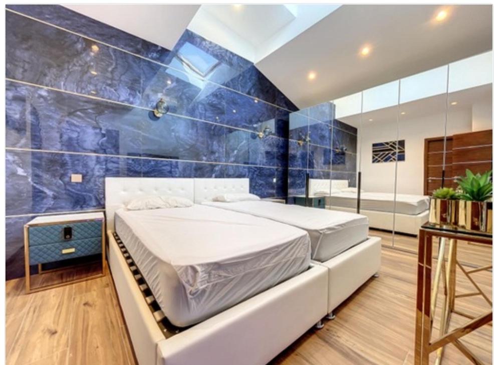 - une chambre avec un lit et un mur bleu dans l'établissement Appartement Palais des Festivals, à Cannes