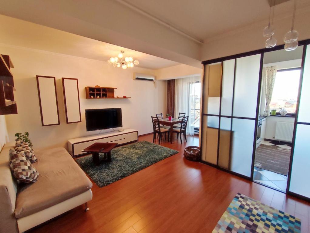 - un salon avec un canapé et une télévision dans l'établissement Aria Premium Apartment, à Bucarest