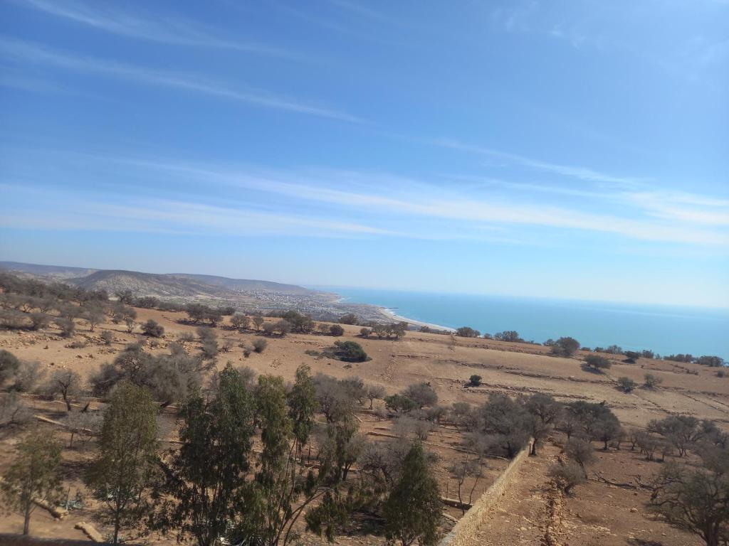 um campo aberto com o oceano ao fundo em Taghazout Océan with pool , fitness and ocean view em Taghazout