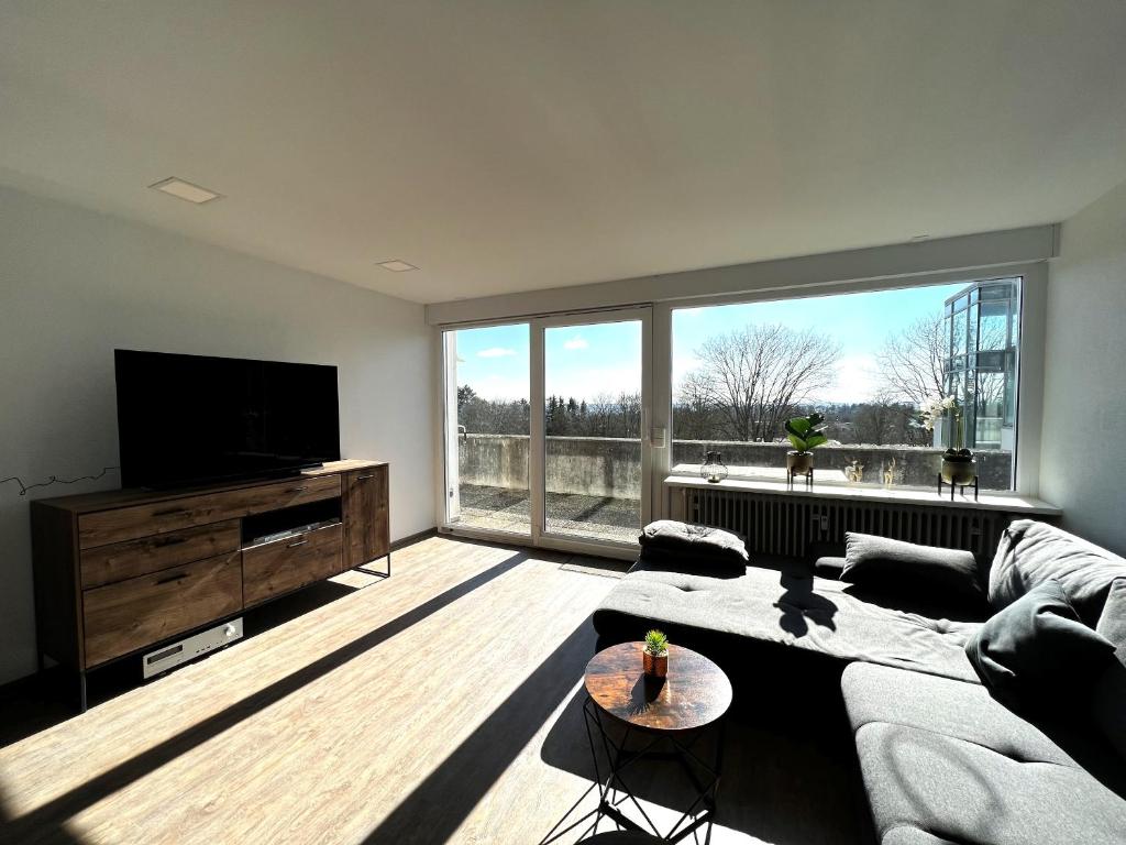 uma sala de estar com um sofá e uma grande janela em SPA-Apartment mit Sauna in Ulm-Böfingen em Ulm