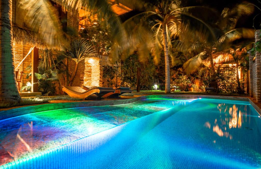 une grande piscine avec des lumières bleues et vertes dans l'établissement Casa Fufi, à Jericoacoara