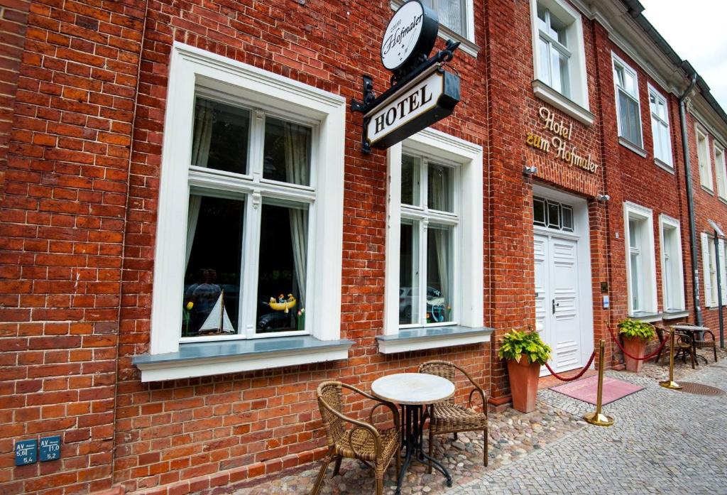 a table and chairs outside of a brick building at Hotel zum Hofmaler in Potsdam