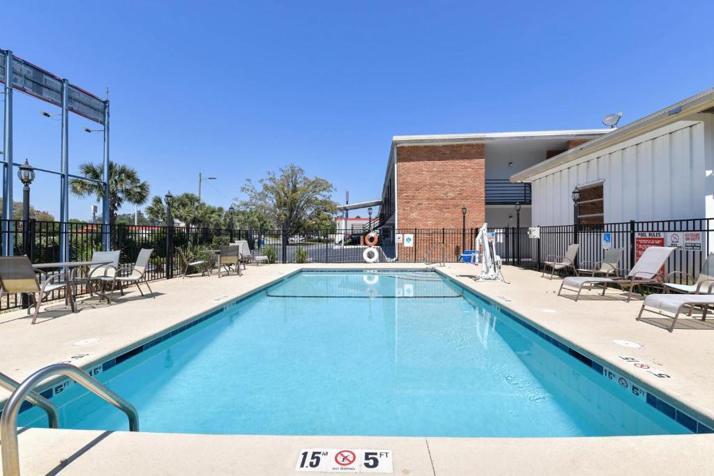 a large swimming pool with chairs and a building at OYO Hotel Valdosta GA I-75 in Valdosta