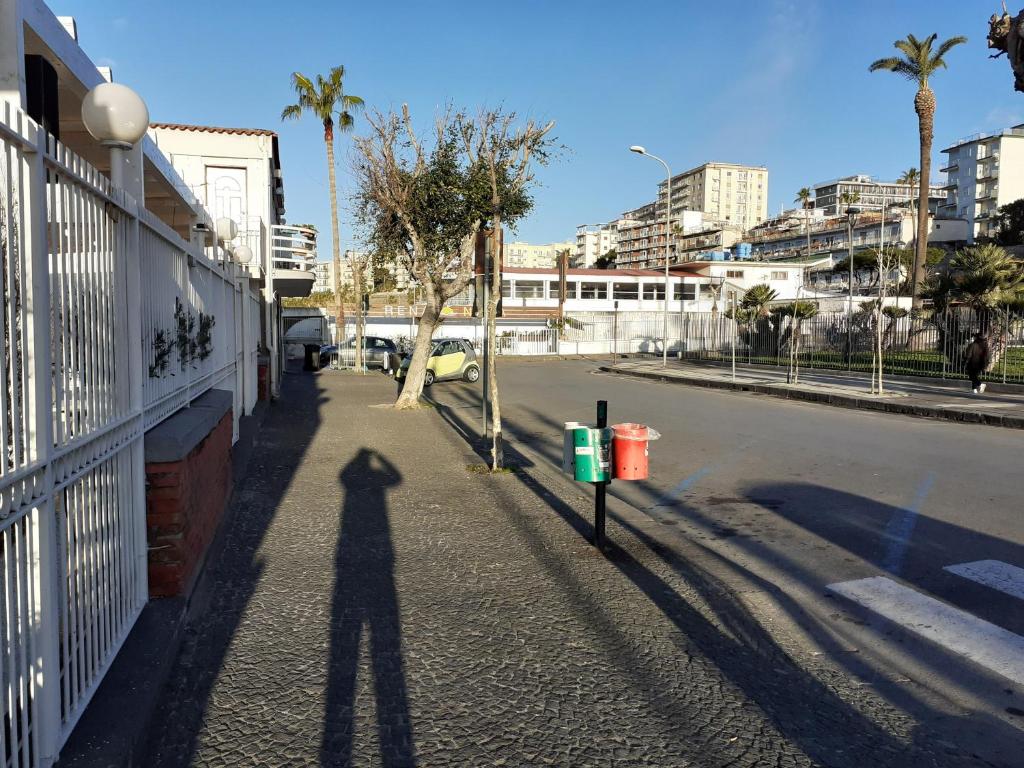 Ein Schatten einer Person, die neben einer Straße steht in der Unterkunft Domvs 84 in Torre Annunziata