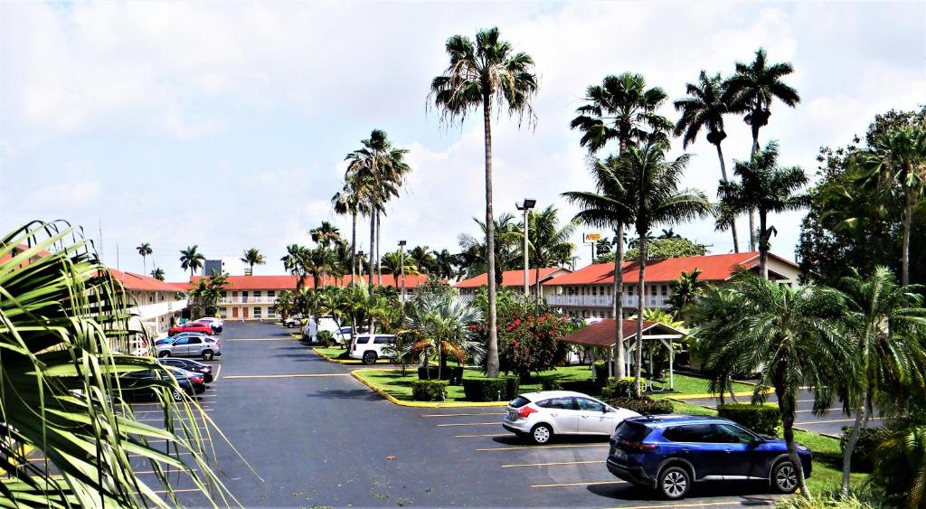 ein Parkplatz mit Autos vor dem Hotel in der Unterkunft Fairway Inn Florida City Homestead Everglades in Florida City