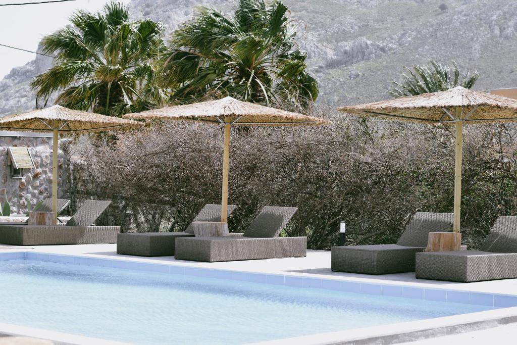 een groep stoelen en parasols naast een zwembad bij LA Casa Di Lusso Grande Casa -Adults Only in Kolimbia