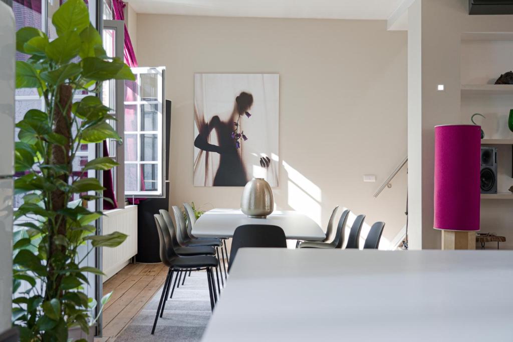 une salle à manger avec une table et des chaises blanches dans l'établissement DUPLEX STYLE NEW-YORKAIS !, à Bruxelles