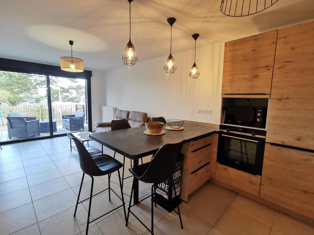 a kitchen with a table and chairs in a room at Les Ganivelles in Donville-les-Bains