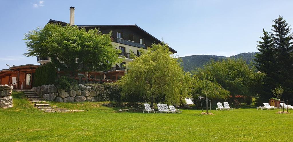 een groep stoelen in het gras voor een gebouw bij Hôtel Restaurant La Buffe in Autrans