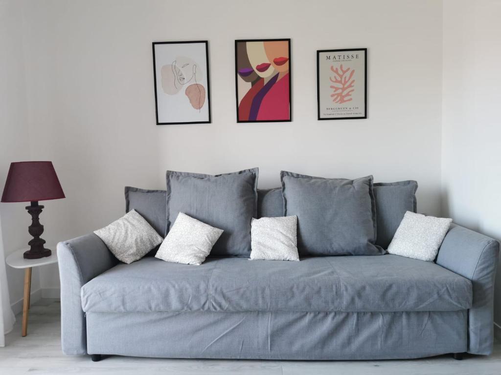 um sofá azul numa sala de estar com fotografias na parede em Dimora Nalu em Bari