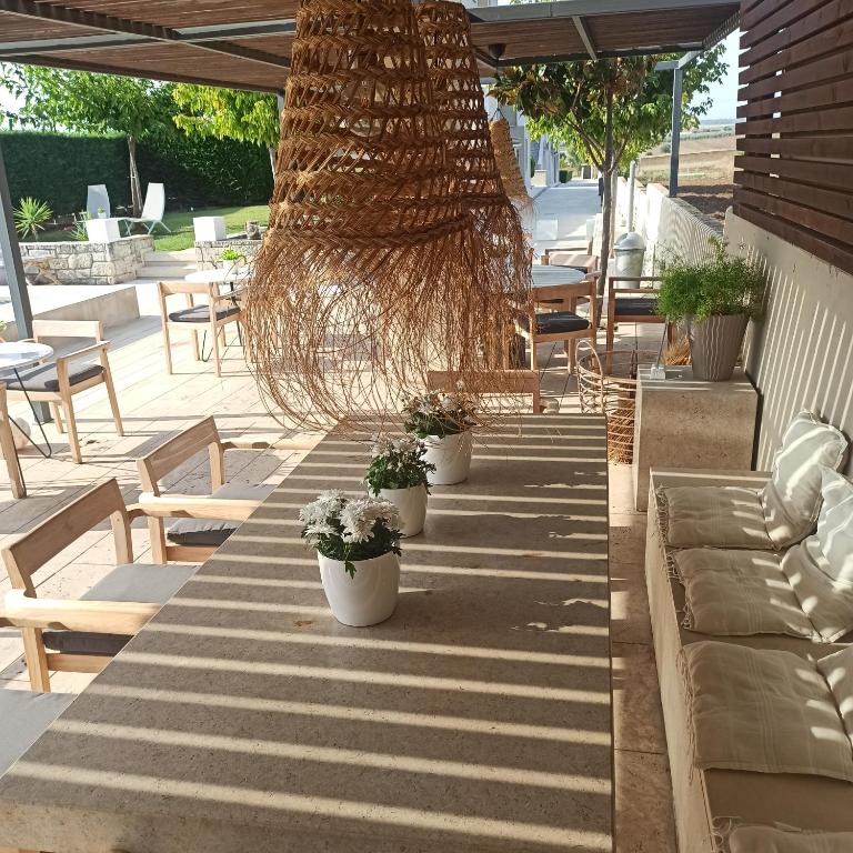 a long table with potted plants on a patio at Niovi Boutique Apartments in Afitos