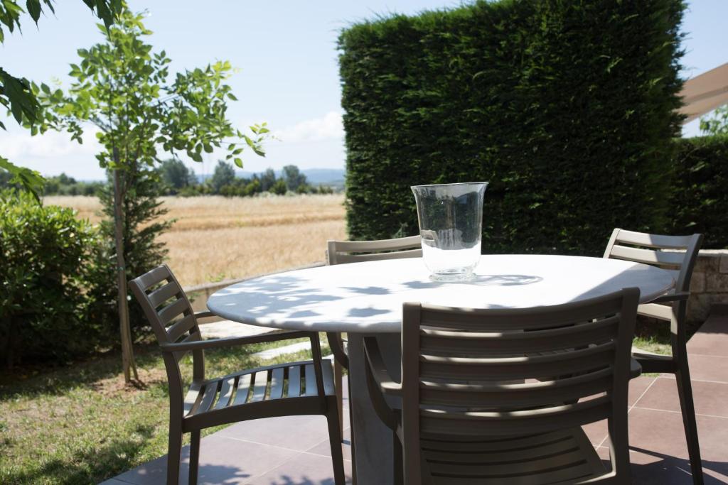 a white table with chairs and a glass on it at Niovi Boutique Apartments in Afitos