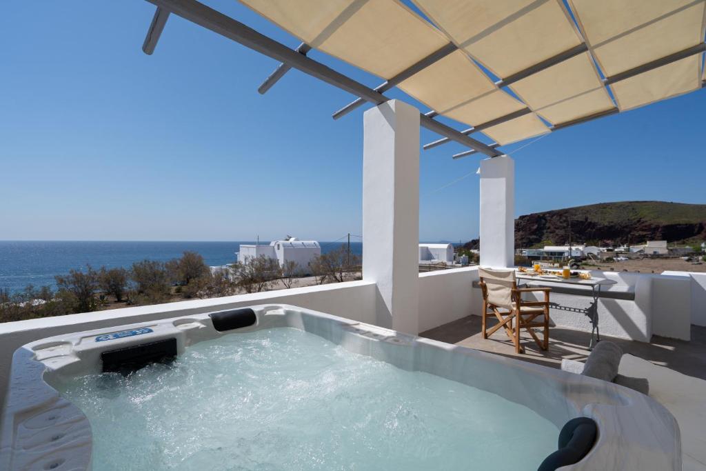 a hot tub on the balcony of a house at Red Beach Harmony suites Modestos in Akrotiri