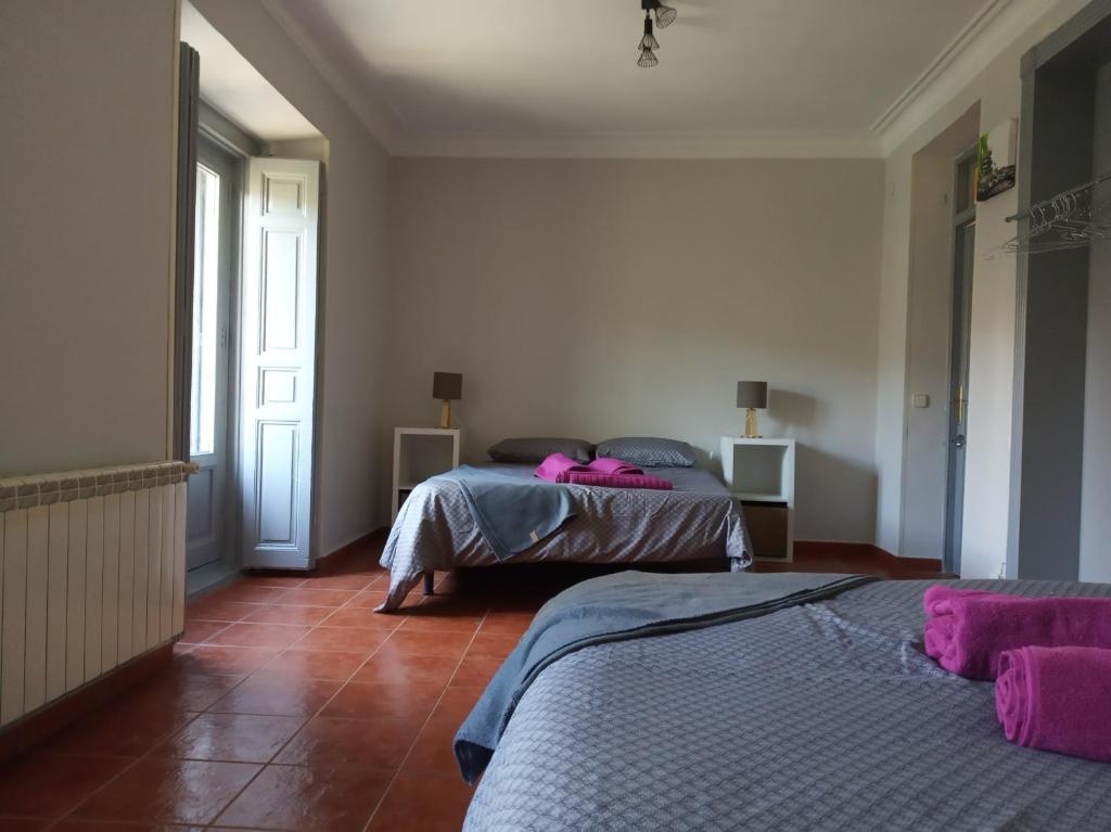 Dos camas en una habitación con toallas rosas. en PME Rooms, en Madrid