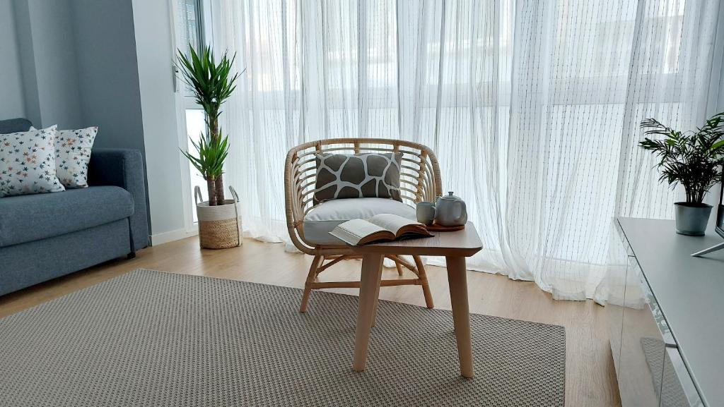 Avante24 في بونتيدويمي: كرسي الخوص مع كتاب على طاولة في غرفة المعيشة