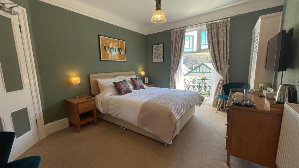 - une chambre avec un lit et une grande fenêtre dans l'établissement Southcliffe B&B, à Lynton