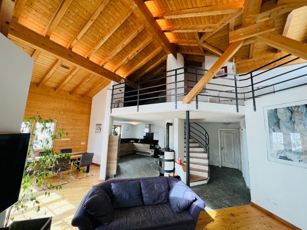 uma sala de estar com um sofá e uma escada em espiral em Maisonette Franz em Vals