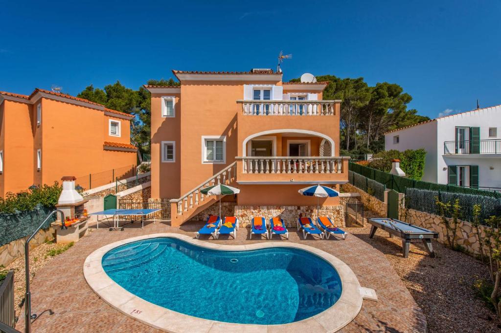 a villa with a swimming pool in front of a house at Villa Dolores by Villa Plus in Cala Galdana