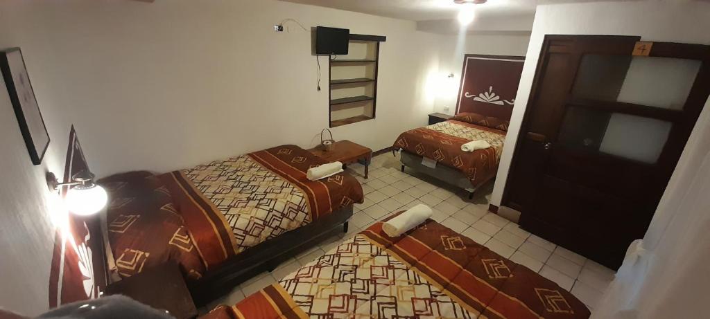 Habitación de hotel con 2 camas y espejo en Hotel Casolia, en Quetzaltenango