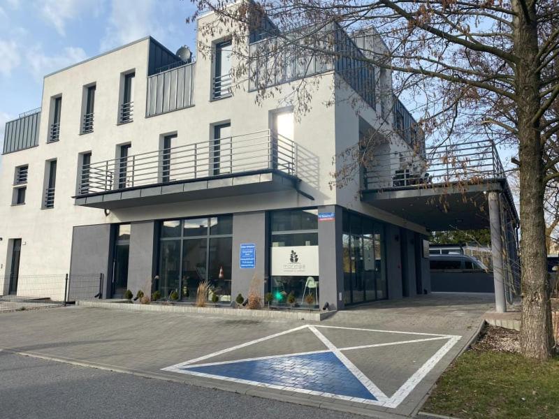 a white building with a parking lot in front of it at Rybacka in Augustów