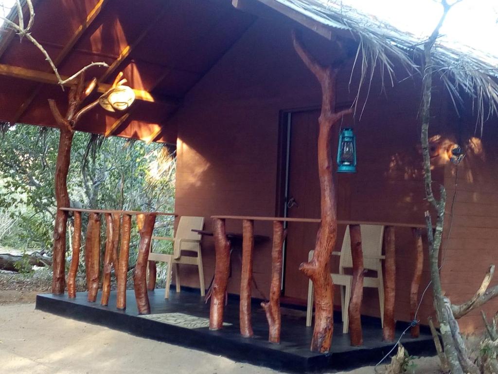 a porch of a house with chairs and a door at Rivosen Camp Yala Safari in Yala