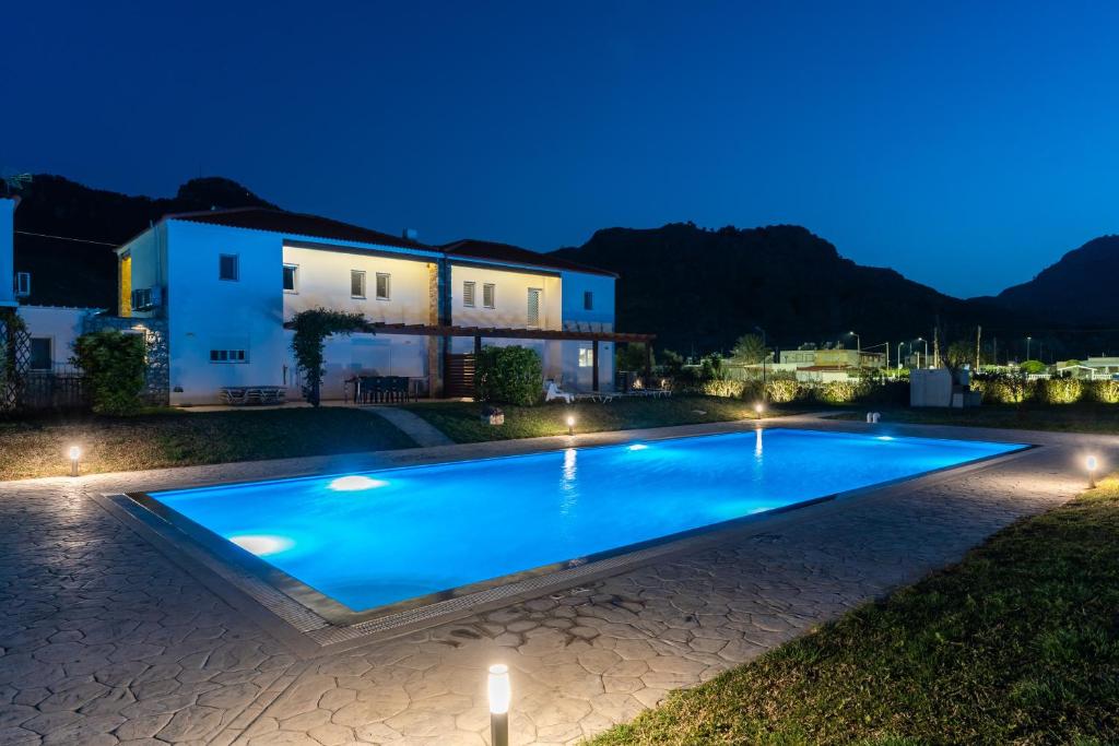 a swimming pool in front of a house at night at Villa Christalia in Kolimbia
